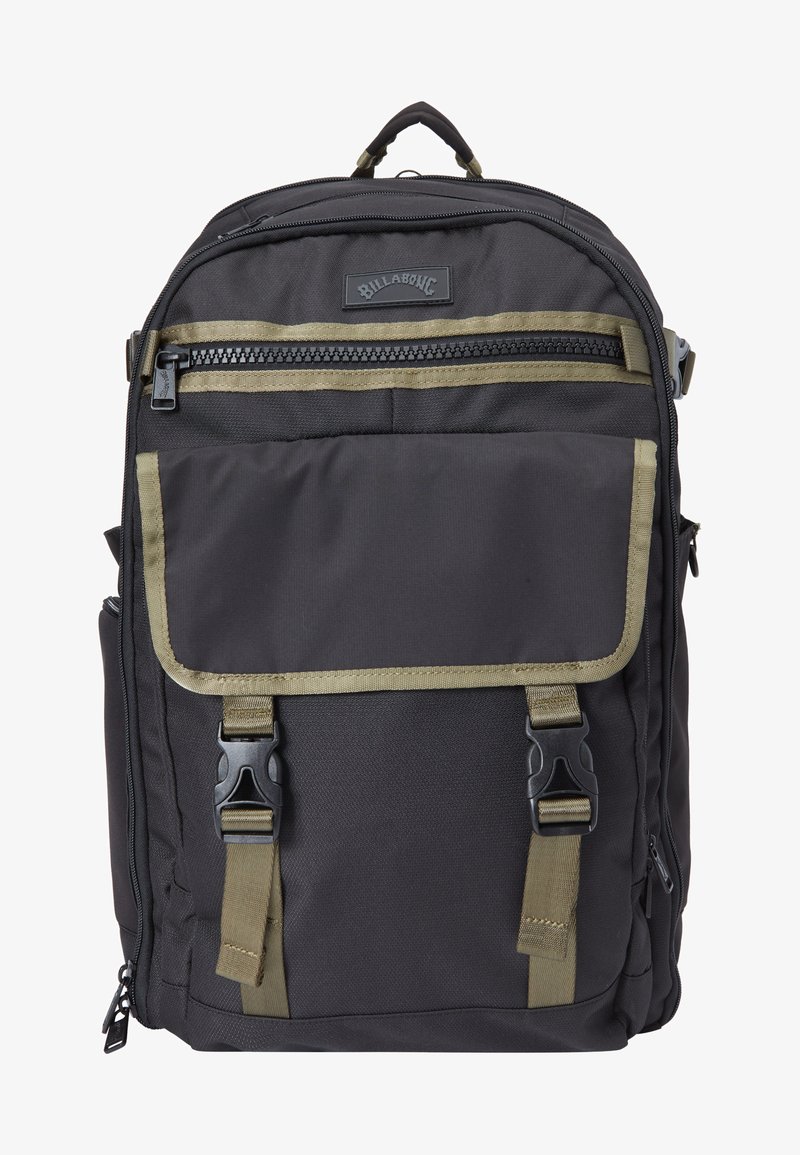 Mochila negra con acentos oliva, fabricada con un tejido duradero. Presenta un bolsillo frontal con cremallera, solapa plegable y correas ajustables.