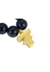 Collana di perline con grandi perle nere lucide, decorata con un ciondolo geometrico oro inciso con "TISSUVILLE". Texture lisce e colori a contrasto.