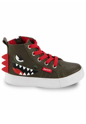 Zapatilla de bota alta para niño con cordones rojos, cuerpo verde oliva oscuro, suela blanca, gráfico de cara de monstruo y picos rojos en el talón.