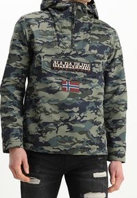 Giacca a pullover con motivo camouflage, con colletto con zip, cappuccio e patch logo sul davanti. Presenta un accento con bandiera norvegese e due tasche davanti.