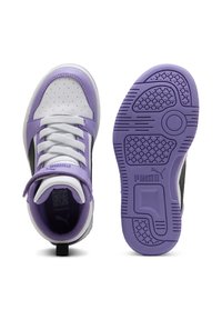 Witte en lavendelkleurige Puma-sneaker met veters, klittenbandsluiting en een paarse, getextureerde zool, weergegeven vanuit boven- en onderaanzichten.