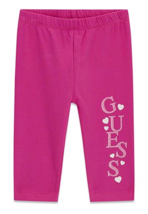 Leggings rosa per bambini con vita elasticizzata e scritta verticale "GUESS" decorata con piccoli cuori su una gamba.