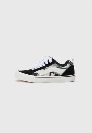 Zwarte suede sneakers met een grijze camo zijpaneel, witte veters en rubberen zool. Voorzien van een gestikt wit logo detail aan de zijkant.