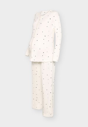Set de pijama pentru maternitate de culoare crem, cu mâneci lungi, bluză cu nasturi în față și buline mici negre împrăștiate atât pe bluză, cât și pe pantaloni.