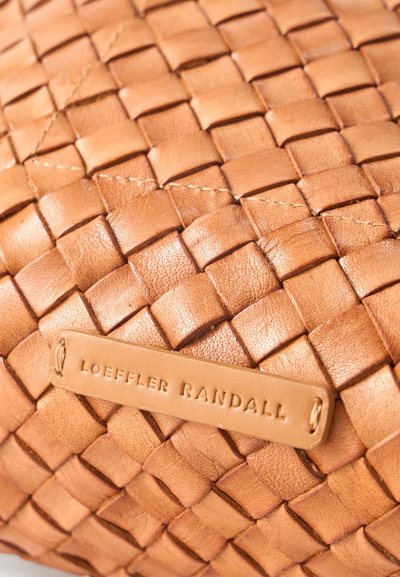 Επιφάνεια από πλεγτό δέρμα καμηλό με ραμμένη δερμάτινη ετικέτα με ανάγλυφη την ένδειξη "Loeffler Randall".