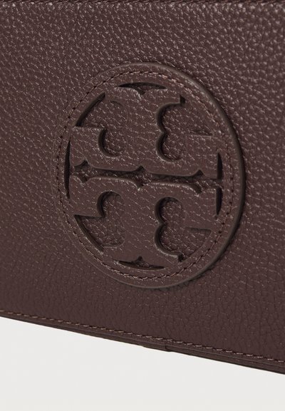 Brown textured leather wallet featuring a circular embossed logo with intertwined letters, surrounded by a stitched border detail.