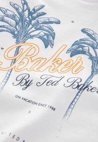 T-shirt bianco in cotone con stampa di una palma blu e testo arancione "Baker", accompagnato da ulteriore testo blu navy e una texture di tessuto liscia.