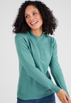 Turquoise gebreide trui met een ronde halslijn, lange mouwen en een vijf-knopen sluiting aan de voorkant. Zachte textuur, geribbelde manchetten en onderkant.