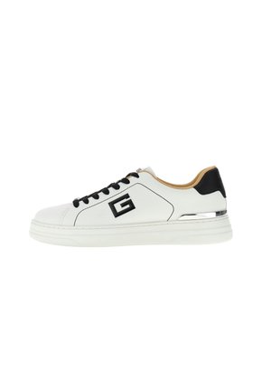 Baskets basses blanches avec lacets noirs, languette de talon noire, doublure intérieure teintée et logo "G" noir sur le côté.