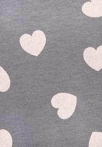 Gray fabric with a textured pattern features scattered light pink heart shapes, creating a playful design. The material appears soft and stretchy.