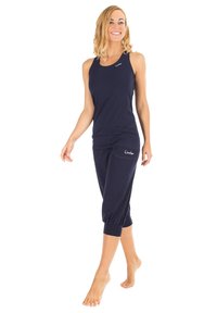 Canotta sportiva blu navy e pantaloni capri. Tessuto morbido, design aderente e orlo risvoltato sui pantaloni. Presenta dettagli con il logo su entrambi i capi.