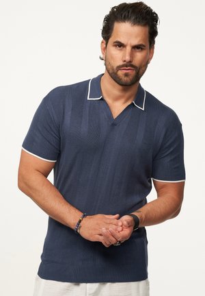 Marineblaues Polohemd mit kurzen Ärmeln, weißen Kragenakzenten und vertikaler Rippstruktur. Verfügt über ein V-Ausschnitt-Design und eine taillierte Silhouette.