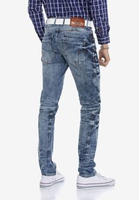 Lichtblauwe denim jeans met een slim fit, voorzien van gedetailleerde stiksels, twee achterzakken en een leren label op de tailleband.