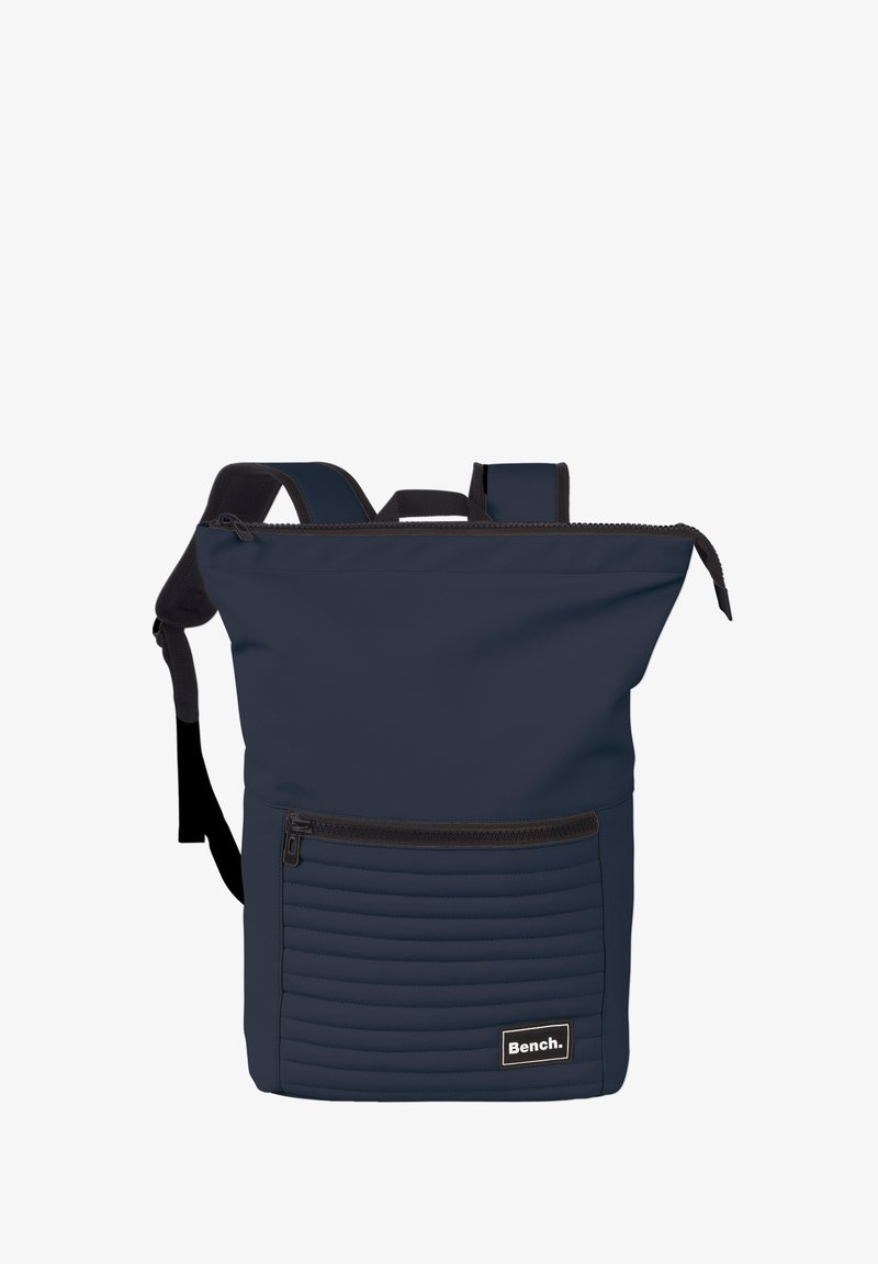 Marineblauwe rugzak van textuurstof met een ritsopening aan de bovenkant, een voorvak met ribbelpatroon en verstelbare schouderbanden.