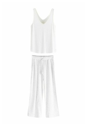 Top bianco senza maniche con scollatura a V e tessuto morbido, abbinato a pantaloni da lounge grigi chiari a gamba larga con vita regolabile.