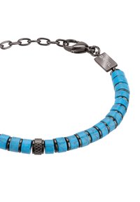 Naszyjnik z turkusowymi koralikami i czarnymi metalowymi akcentami, z cylindrycznymi koralikami i teksturowanym centralnym spacem. Bezpieczne zapięcie z metką marki.
