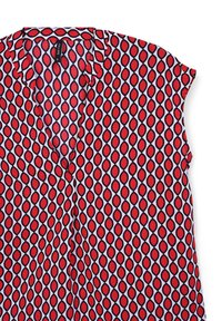Blusa a maniche corte in tessuto leggero con un motivo a rombi rosso e bianco contornato di nero. Presenta un collo a V e un colletto ripiegato.