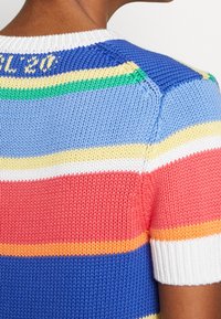 Flerfärgad stickad kortärmad tröja med ränder i blått, rosa, gult och grönt. Har en vit ribbad krage och texturerat tyg.