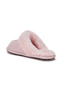Rosa mockasiner i mocka med en fluffig pälsfoder och öppen baksida, samt en texturerad gummisula för bra grepp.