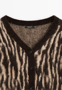 Cardigan brun et beige à rayures zèbre duveteux avec boutons noirs et col en V, étiquette Massimo Dutti.