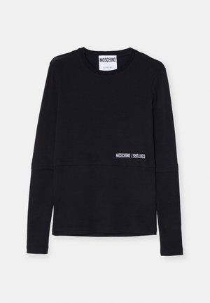 Fekete, hosszú ujjú felső, puha anyagból, kerek nyakkivágással, vízszintes varrással, amelyen fehér betűkkel a "Moschino Couture!" felirat található a szegélyen.