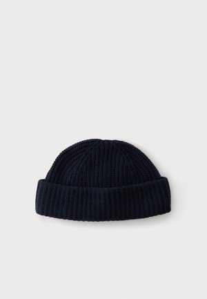 Bonnet côtelé bleu marine foncé avec bord replié sur fond blanc uni.