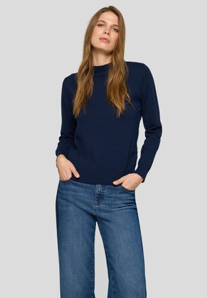 Navy sweater with a crew neckline, ribbed cuffs, and hem, paired with wide-leg blue jeans. Smooth texture and casual fit.