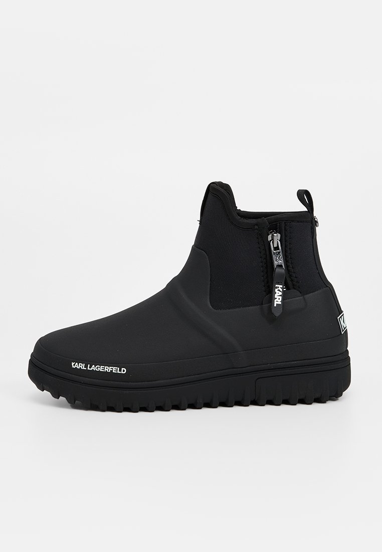 Czarne wodoodporne botki za kostkę wykonane z gumy i tekstyliów. Posiadają boczny zamek błyskawiczny, teksturowaną cholewkę oraz masywną, wzorzystą podeszwę.