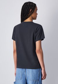 Zwarte katoenen t-shirt met korte mouwen, ronde hals en een eenvoudig ontwerp, zonder zichtbare patronen of graphics.