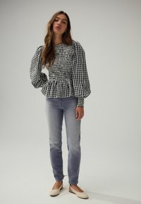 Ruud mustriline must-valge smockitud top, puffvarrukatega, peplum äär; kantud heledate teksade ja beezide slingback jalanõudega.