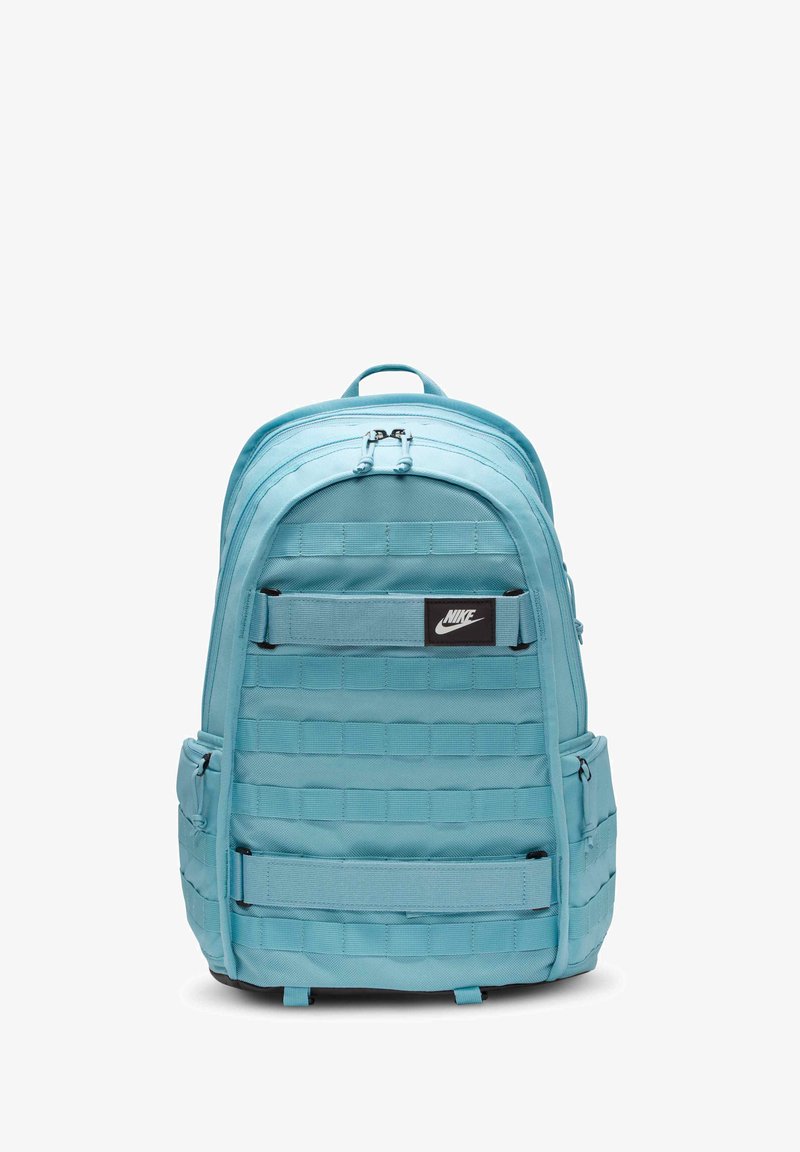 Rucsac Nike de culoare albastru deschis, cu un design structurat, care include curele verticale, compartimente cu fermoar și o emblema de marcă neagră.