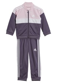Completo da ginnastica Adidas in viola e rosa. Include una giacca con zip e strisce bianche, insieme a pantaloni coordinati. Realizzato in un tessuto liscio e elasticizzato.