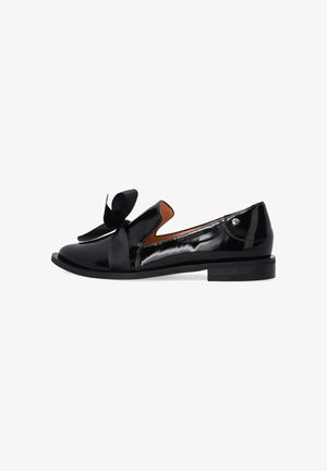 Schwarze Lackleder-Loafer mit einer Bogenakzent, offen an der Seite und flachem Absatz. Elegantes Design mit glänzender Oberfläche und kontrastierendem braunen Innenraum.