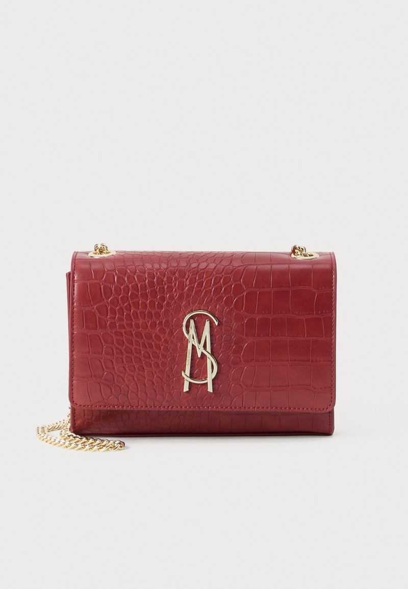 Bolso de hombro de cuero texturizado en forma de cocodrilo rojo con correa de cadena dorada y logotipo dorado "MS" en la solapa frontal.