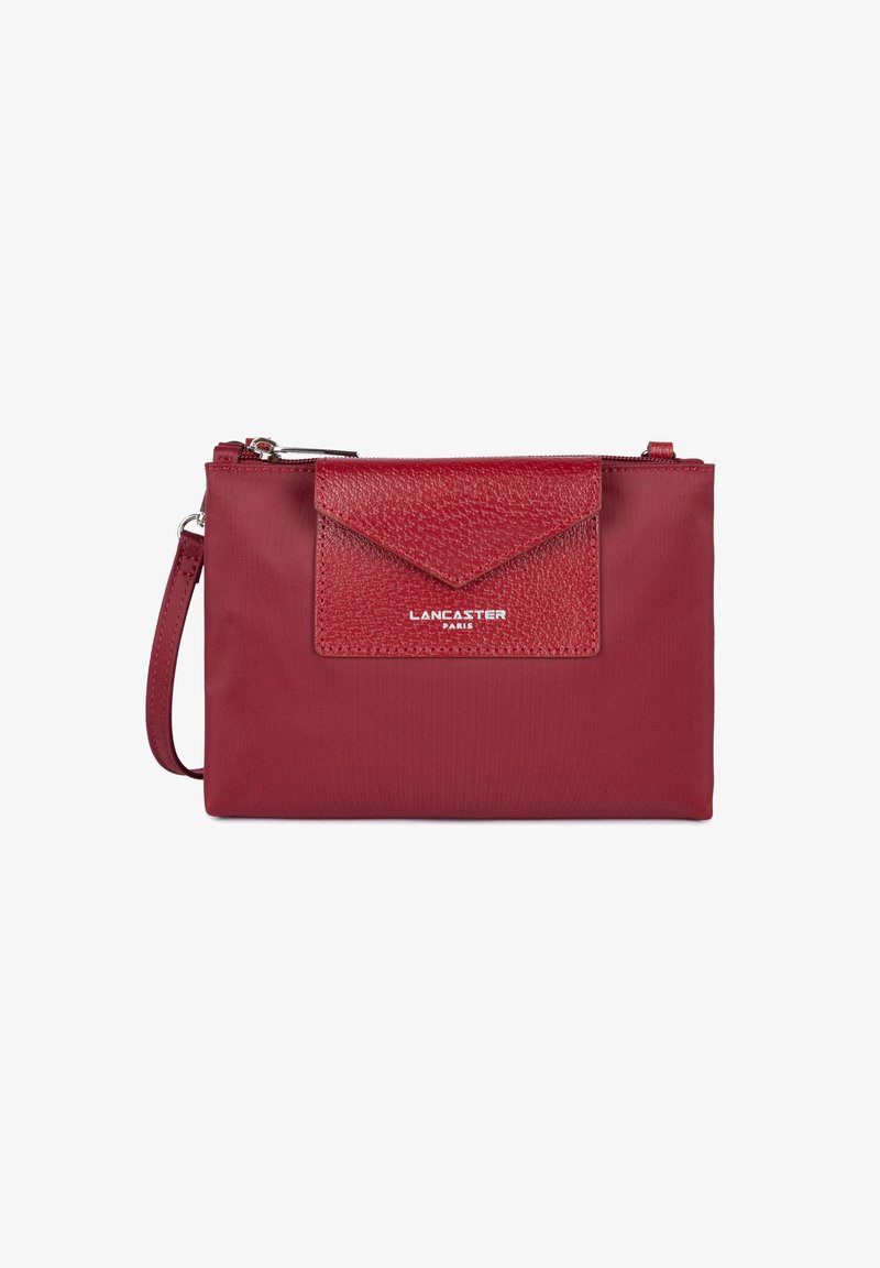 Rote Handtasche mit einer strukturierten Lederklappe und einem glatten Stoffkörper. Enthält einen Reißverschluss und einen befestigten Handgelenkriemen für einfache Tragbarkeit.