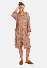 Bloemmotief beige cover-up met een ontspannen pasvorm, lange mouwen, twee zakken en gestreepte accenten op de manchetten, gemaakt van zachte, lichte stof.