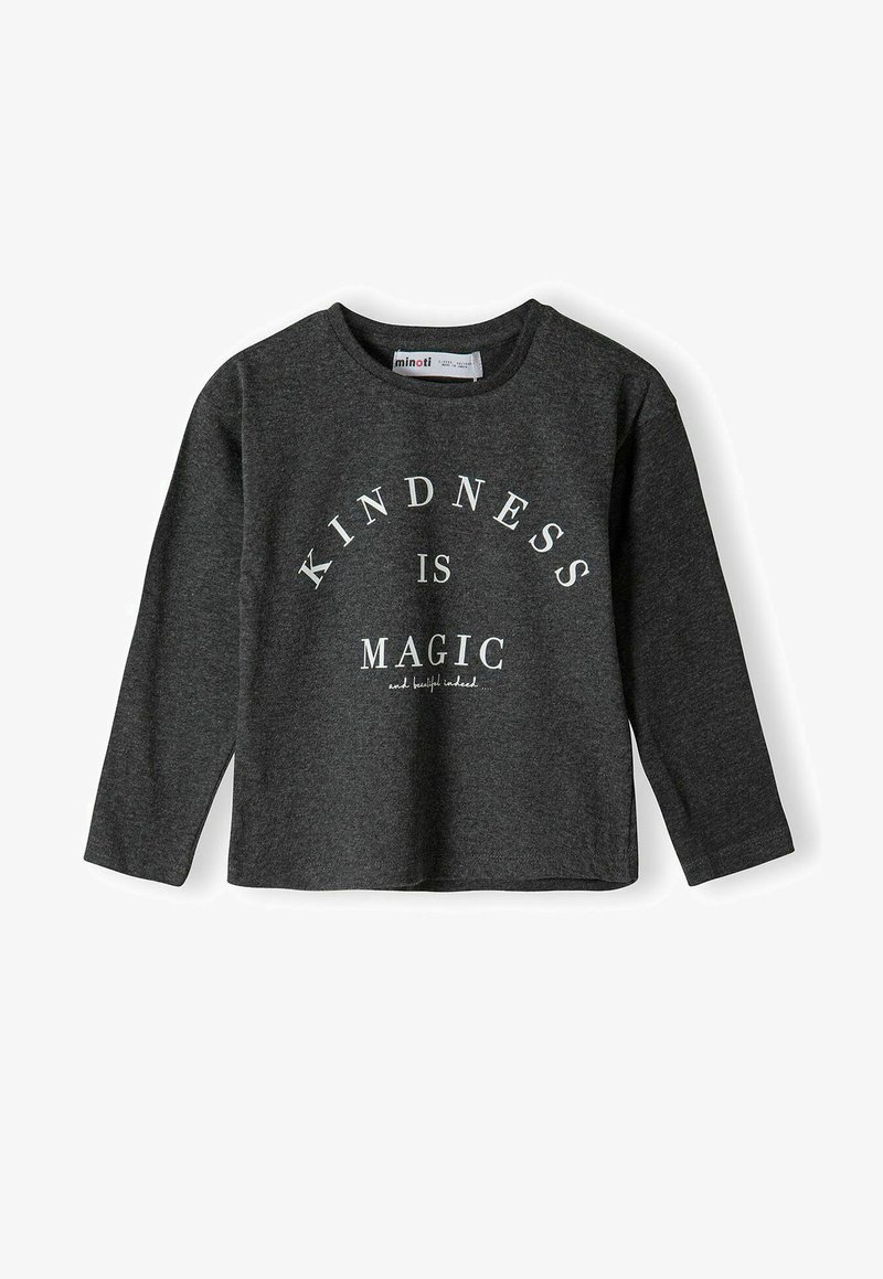 Sötét szürke, hosszú ujjú póló, puha anyagból, amelyen fehér felirat található: "A kedvesség varázslat" kör alakú elrendezésben, alatta további szöveggel.