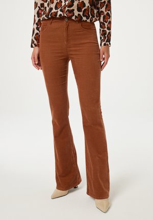 Brown corduroy flared pants with front pockets and a button closure, paired with a patterned long-sleeve top and pointed beige heels.