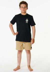 Black short-sleeve T-shirt with colorful logo on chest, paired with khaki shorts. Barefoot stance on plain white background.