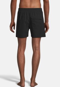 Zwarte zwemshorts van lichtgewicht stof, met een elastische tailleband en een achterzak met knoopsluiting, van de achterkant getoond.