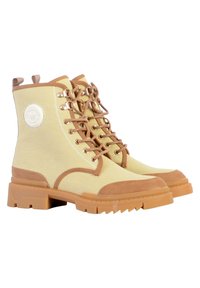 Gele canvas enkelboots met bruine suède accenten, voorzien van metalen oogjes, vetersluiting en stevige rubberen zolen. Ronde logo-detail aan de zijkant.
