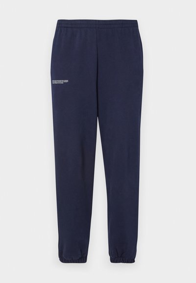Sötétkék pamut melegítőnadrág, elasztikus derékrésszel és nadrágszárral, fehér szöveges részletezéssel a bal comb felső részén.