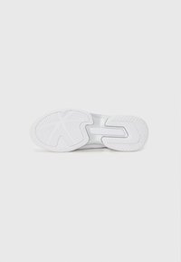 Semelle de chaussure de sport blanche avec caoutchouc texturé pour l'adhérence, dotée d'un motif de semelle distinctif et d'un design de semelle intermédiaire lisse.