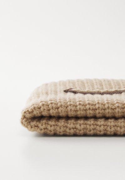 Beige knitted accessory with a textured pattern, folded over with a dark accent detail, showcasing soft wool-like material.