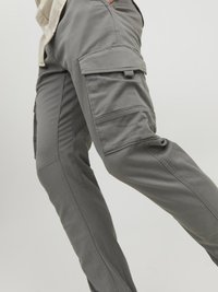 Cargo pants in gray fabric featuring multiple pockets, a slim fit, and visible stitching details along the legs for added texture.