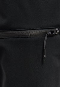 Zwarte sportbroek met een gladde textuur en een slim fit, uitgerust met een horizontale ritszak voor veilige opberging.
