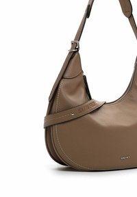Braune Lederhandtasche mit geschwungener Form, ausgestattet mit einem Reißverschluss, einem stabilen Riemen mit Schnalle und einer geprägten Markenkennzeichnung an der Seite.