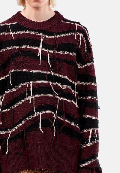 Maglione oversize lavorato a maglia in bordeaux e nero, con righe orizzontali e dettagli sfrangiati. Collo e polsini a costine.