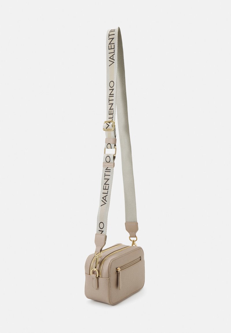 Borsa a tracolla in pelle beige con dettagli in oro, doppie cerniere e una tracolla in tessuto con il logo Valentino. Design compatto e rettangolare.