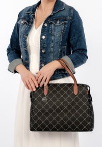 Black handbag with diamond pattern, brown leather handles, and silver hardware details. Smooth texture with a structured shape.